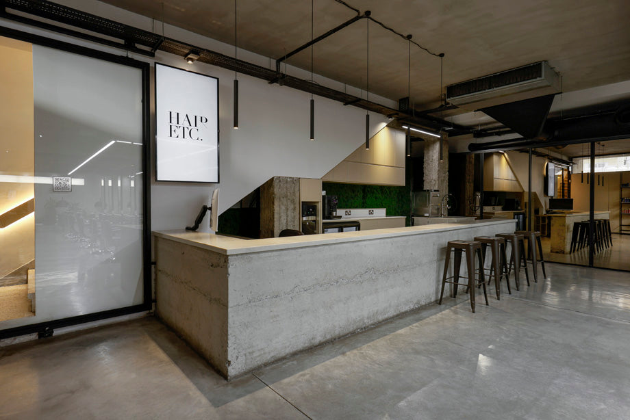 Modern reception area interior with a concrete countertop and 'HAIR ETC.' sign.